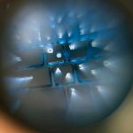 Image of a magnifying glass looking at a computer keyboard.